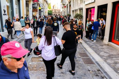 Atina, Yunanistan - Yunanistan - 07 Kasım 2021 Coronavirüs salgını sırasında Ermou Caddesi 'nde yürüyen ve alışveriş yapan kalabalık, maskeyi sokakta takmak zorunda değil, fakat pek çok kişi takıyor.
