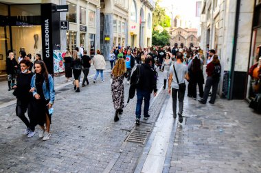 Atina, Yunanistan - Yunanistan - 07 Kasım 2021 Coronavirüs salgını sırasında Ermou Caddesi 'nde yürüyen ve alışveriş yapan kalabalık, maskeyi sokakta takmak zorunda değil, fakat pek çok kişi takıyor.