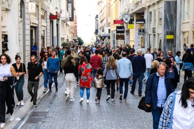 Atina, Yunanistan - Yunanistan - 07 Kasım 2021 Coronavirüs salgını sırasında Ermou Caddesi 'nde yürüyen ve alışveriş yapan kalabalık, maskeyi sokakta takmak zorunda değil, fakat pek çok kişi takıyor.