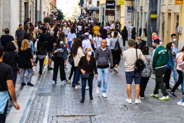 Atina, Yunanistan - Yunanistan - 07 Kasım 2021 Coronavirüs salgını sırasında Ermou Caddesi 'nde yürüyen ve alışveriş yapan kalabalık, maskeyi sokakta takmak zorunda değil, fakat pek çok kişi takıyor.