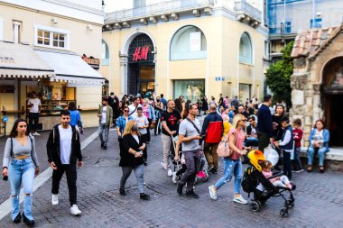Atina, Yunanistan - Yunanistan - 07 Kasım 2021 Coronavirüs salgını sırasında Ermou Caddesi 'nde yürüyen ve alışveriş yapan kalabalık, maskeyi sokakta takmak zorunda değil, fakat pek çok kişi takıyor.