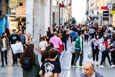 Atina, Yunanistan - Yunanistan - 07 Kasım 2021 Coronavirüs salgını sırasında Ermou Caddesi 'nde yürüyen ve alışveriş yapan kalabalık, maskeyi sokakta takmak zorunda değil, fakat pek çok kişi takıyor.
