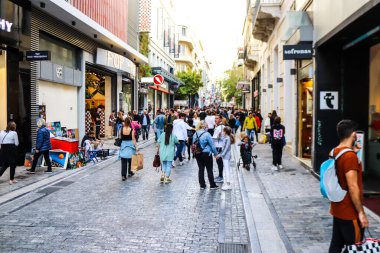 Atina, Yunanistan - Yunanistan - 07 Kasım 2021 Coronavirüs salgını sırasında Ermou Caddesi 'nde yürüyen ve alışveriş yapan kalabalık, maskeyi sokakta takmak zorunda değil, fakat pek çok kişi takıyor.