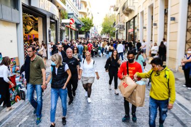 Atina, Yunanistan - Yunanistan - 07 Kasım 2021 Coronavirüs salgını sırasında Ermou Caddesi 'nde yürüyen ve alışveriş yapan kalabalık, maskeyi sokakta takmak zorunda değil, fakat pek çok kişi takıyor.