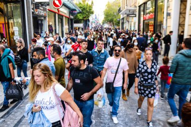 Atina, Yunanistan - Yunanistan - 07 Kasım 2021 Coronavirüs salgını sırasında Ermou Caddesi 'nde yürüyen ve alışveriş yapan kalabalık, maskeyi sokakta takmak zorunda değil, fakat pek çok kişi takıyor.