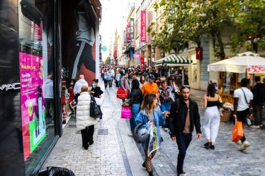 Atina, Yunanistan - Yunanistan - 07 Kasım 2021 Coronavirüs salgını sırasında Ermou Caddesi 'nde yürüyen ve alışveriş yapan kalabalık, maskeyi sokakta takmak zorunda değil, fakat pek çok kişi takıyor.