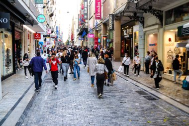 Atina, Yunanistan - Yunanistan - 07 Kasım 2021 Coronavirüs salgını sırasında Ermou Caddesi 'nde yürüyen ve alışveriş yapan kalabalık, maskeyi sokakta takmak zorunda değil, fakat pek çok kişi takıyor.