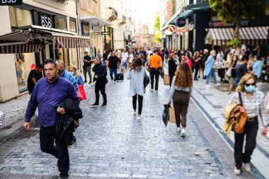Atina, Yunanistan - Yunanistan - 07 Kasım 2021 Coronavirüs salgını sırasında Ermou Caddesi 'nde yürüyen ve alışveriş yapan kalabalık, maskeyi sokakta takmak zorunda değil, fakat pek çok kişi takıyor.