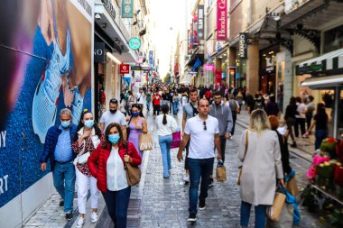 Atina, Yunanistan - Yunanistan - 07 Kasım 2021 Coronavirüs salgını sırasında Ermou Caddesi 'nde yürüyen ve alışveriş yapan kalabalık, maskeyi sokakta takmak zorunda değil, fakat pek çok kişi takıyor.
