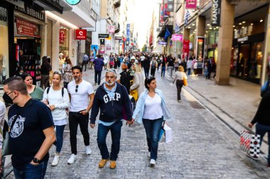 Atina, Yunanistan - Yunanistan - 07 Kasım 2021 Coronavirüs salgını sırasında Ermou Caddesi 'nde yürüyen ve alışveriş yapan kalabalık, maskeyi sokakta takmak zorunda değil, fakat pek çok kişi takıyor.