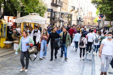 Atina, Yunanistan - Yunanistan - 07 Kasım 2021 Coronavirüs salgını sırasında Ermou Caddesi 'nde yürüyen ve alışveriş yapan kalabalık, maskeyi sokakta takmak zorunda değil, fakat pek çok kişi takıyor.