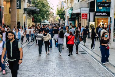 Atina, Yunanistan - Yunanistan - 07 Kasım 2021 Coronavirüs salgını sırasında Ermou Caddesi 'nde yürüyen ve alışveriş yapan kalabalık, maskeyi sokakta takmak zorunda değil, fakat pek çok kişi takıyor.