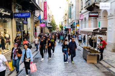 Atina, Yunanistan - Yunanistan - 07 Kasım 2021 Coronavirüs salgını sırasında Ermou Caddesi 'nde yürüyen ve alışveriş yapan kalabalık, maskeyi sokakta takmak zorunda değil, fakat pek çok kişi takıyor.