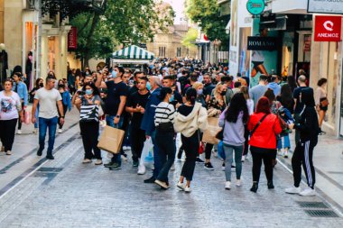 Atina, Yunanistan - Yunanistan - 07 Kasım 2021 Coronavirüs salgını sırasında Ermou Caddesi 'nde yürüyen ve alışveriş yapan kalabalık, maskeyi sokakta takmak zorunda değil, fakat pek çok kişi takıyor.