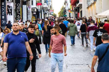 Atina, Yunanistan - Yunanistan - 07 Kasım 2021 Coronavirüs salgını sırasında Ermou Caddesi 'nde yürüyen ve alışveriş yapan kalabalık, maskeyi sokakta takmak zorunda değil, fakat pek çok kişi takıyor.
