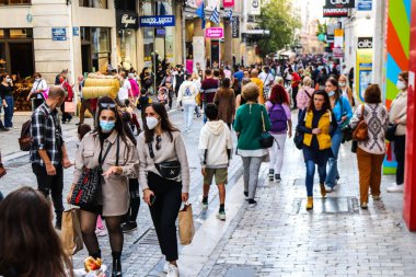 Atina, Yunanistan - Yunanistan - 07 Kasım 2021 Coronavirüs salgını sırasında Ermou Caddesi 'nde yürüyen ve alışveriş yapan kalabalık, maskeyi sokakta takmak zorunda değil, fakat pek çok kişi takıyor.