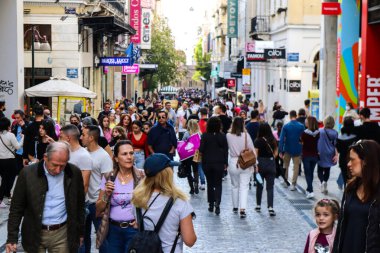 Atina, Yunanistan - Yunanistan - 07 Kasım 2021 Coronavirüs salgını sırasında Ermou Caddesi 'nde yürüyen ve alışveriş yapan kalabalık, maskeyi sokakta takmak zorunda değil, fakat pek çok kişi takıyor.