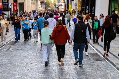 Atina, Yunanistan - Yunanistan - 07 Kasım 2021 Coronavirüs salgını sırasında Ermou Caddesi 'nde yürüyen ve alışveriş yapan kalabalık, maskeyi sokakta takmak zorunda değil, fakat pek çok kişi takıyor.