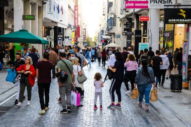 Atina, Yunanistan - Yunanistan - 07 Kasım 2021 Coronavirüs salgını sırasında Ermou Caddesi 'nde yürüyen ve alışveriş yapan kalabalık, maskeyi sokakta takmak zorunda değil, fakat pek çok kişi takıyor.