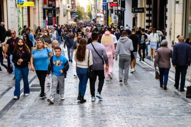 Atina, Yunanistan - Yunanistan - 07 Kasım 2021 Coronavirüs salgını sırasında Ermou Caddesi 'nde yürüyen ve alışveriş yapan kalabalık, maskeyi sokakta takmak zorunda değil, fakat pek çok kişi takıyor.