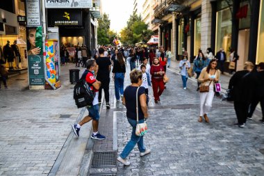 Atina, Yunanistan - Yunanistan - 07 Kasım 2021 Coronavirüs salgını sırasında Ermou Caddesi 'nde yürüyen ve alışveriş yapan kalabalık, maskeyi sokakta takmak zorunda değil, fakat pek çok kişi takıyor.
