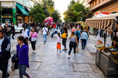 Atina, Yunanistan - Yunanistan - 07 Kasım 2021 Coronavirüs salgını sırasında Ermou Caddesi 'nde yürüyen ve alışveriş yapan kalabalık, maskeyi sokakta takmak zorunda değil, fakat pek çok kişi takıyor.