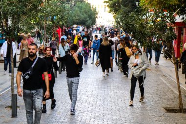 Atina, Yunanistan - Yunanistan - 07 Kasım 2021 Coronavirüs salgını sırasında Ermou Caddesi 'nde yürüyen ve alışveriş yapan kalabalık, maskeyi sokakta takmak zorunda değil, fakat pek çok kişi takıyor.