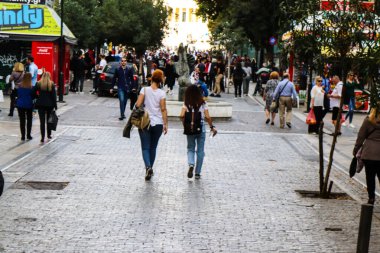 Atina, Yunanistan - Yunanistan - 07 Kasım 2021 Coronavirüs salgını sırasında Ermou Caddesi 'nde yürüyen ve alışveriş yapan kalabalık, maskeyi sokakta takmak zorunda değil, fakat pek çok kişi takıyor.