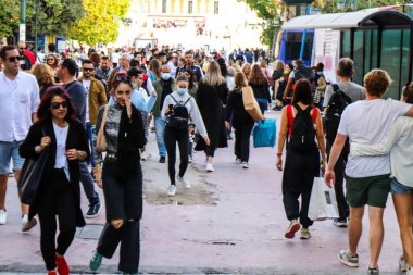 Atina, Yunanistan - Yunanistan - 07 Kasım 2021 Coronavirüs salgını sırasında Ermou Caddesi 'nde yürüyen ve alışveriş yapan kalabalık, maskeyi sokakta takmak zorunda değil, fakat pek çok kişi takıyor.