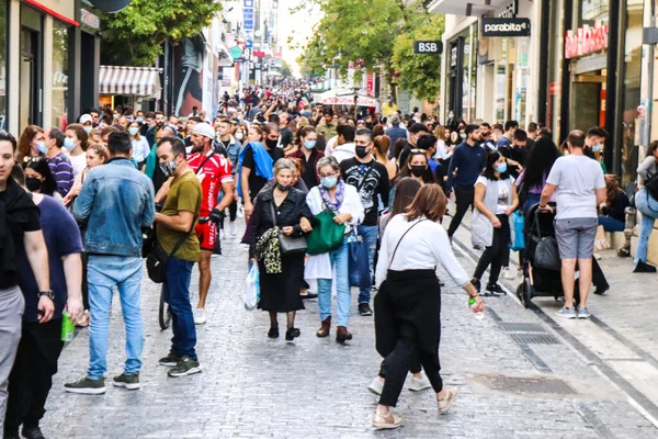 Atina, Yunanistan - Yunanistan - 07 Kasım 2021 Coronavirüs salgını sırasında Ermou Caddesi 'nde yürüyen ve alışveriş yapan kalabalık, maskeyi sokakta takmak zorunda değil, fakat pek çok kişi takıyor.