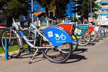 Limasol, Kıbrıs - 26 Kasım 2021 'de Kıbrıs Rum Kesimi' nde meydana gelen koronavirüs salgını sırasında Limasol sokaklarında park halindeki bisikletleri kiralamak zorunludur.