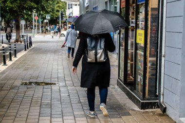 Tel Aviv, İsrail - 8 Şubat 2022 Tel Aviv sokaklarında yürüyen şemsiyeli yayalar Coronavirus salgını sırasında İsrail 'i vurdu