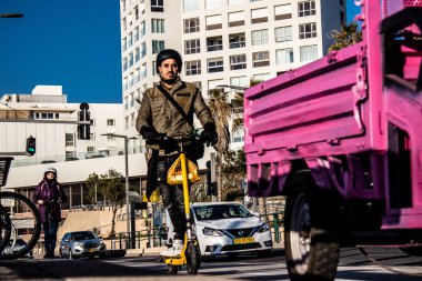 Tel Aviv, İsrail - 11 Şubat 2022 Tel Aviv sokaklarında elektrikli scooter kullanan insanlar, küçük bir iç yanmalı motorlar ve merkezde bir güverte ile çalışıyorlar.