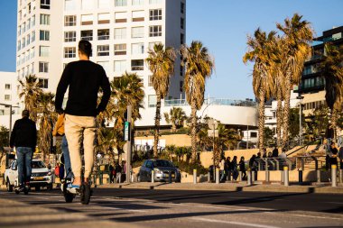 Tel Aviv, İsrail - 11 Şubat 2022 Tel Aviv sokaklarında elektrikli scooter kullanan insanlar, küçük bir iç yanmalı motorlar ve merkezde bir güverte ile çalışıyorlar.