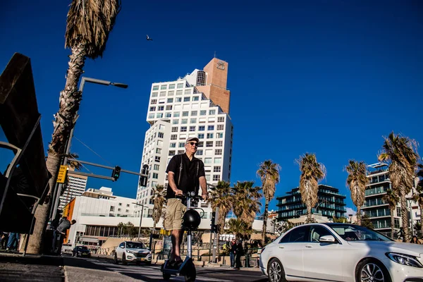 Tel Aviv, İsrail - 11 Şubat 2022 Tel Aviv sokaklarında elektrikli scooter kullanan insanlar, küçük bir iç yanmalı motorlar ve merkezde bir güverte ile çalışıyorlar.