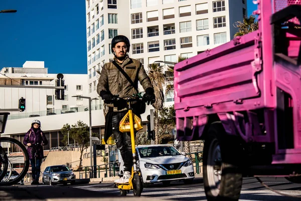Tel Aviv, İsrail - 11 Şubat 2022 Tel Aviv sokaklarında elektrikli scooter kullanan insanlar, küçük bir iç yanmalı motorlar ve merkezde bir güverte ile çalışıyorlar.