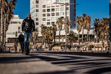 Tel Aviv, İsrail - 11 Şubat 2022 Tel Aviv sokaklarında elektrikli scooter kullanan insanlar, küçük bir iç yanmalı motorlar ve merkezde bir güverte ile çalışıyorlar.