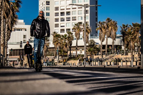 Tel Aviv, İsrail - 11 Şubat 2022 Tel Aviv sokaklarında elektrikli scooter kullanan insanlar, küçük bir iç yanmalı motorlar ve merkezde bir güverte ile çalışıyorlar.
