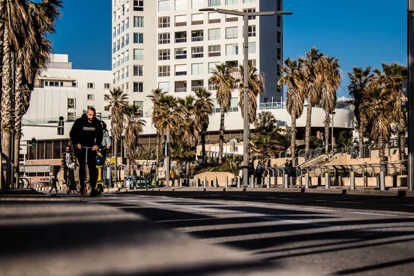 Tel Aviv, İsrail - 11 Şubat 2022 Tel Aviv sokaklarında elektrikli scooter kullanan insanlar, küçük bir iç yanmalı motorlar ve merkezde bir güverte ile çalışıyorlar.
