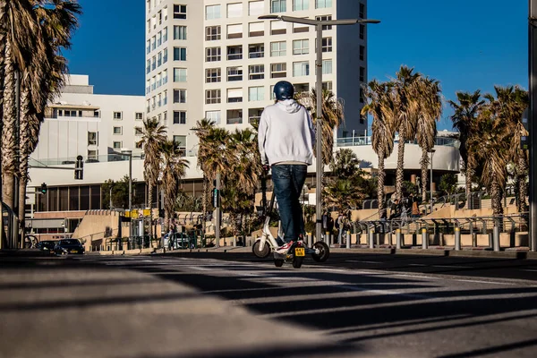 Tel Aviv, İsrail - 11 Şubat 2022 Tel Aviv sokaklarında elektrikli scooter kullanan insanlar, küçük bir iç yanmalı motorlar ve merkezde bir güverte ile çalışıyorlar.