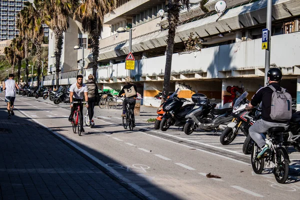 Tel Aviv, İsrail - 11 Şubat 2022 İsrail 'de Tel Aviv sokaklarında bisikletle gezen insanlar