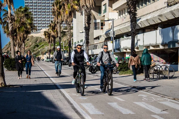 Tel Aviv, İsrail - 11 Şubat 2022 İsrail 'de Tel Aviv sokaklarında bisikletle gezen insanlar