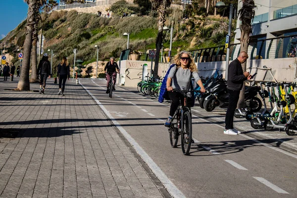 Tel Aviv, İsrail - 11 Şubat 2022 İsrail 'de Tel Aviv sokaklarında bisikletle gezen insanlar
