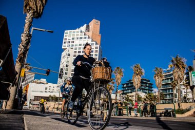 Tel Aviv, İsrail - 11 Şubat 2022 İsrail 'de Tel Aviv sokaklarında bisikletle gezen insanlar