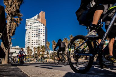 Tel Aviv, İsrail - 11 Şubat 2022 İsrail 'de Tel Aviv sokaklarında bisikletle gezen insanlar