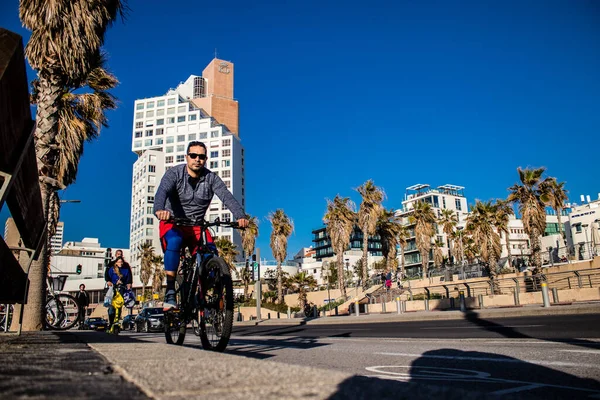 Tel Aviv, İsrail - 11 Şubat 2022 İsrail 'de Tel Aviv sokaklarında bisikletle gezen insanlar