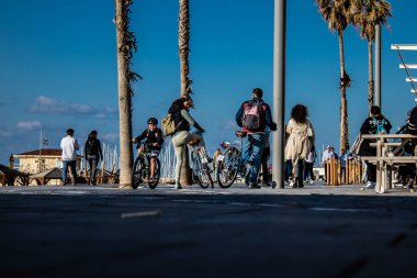 Tel Aviv, İsrail - 13 Şubat 2022 Tel Aviv Güvertesi 'nde yürüyen kimliği belirsiz insanlar, İbranice' de Tayelet olarak bilinir, İsrail 'in Tel Aviv kentindeki Akdeniz kıyısı boyunca uzanır.