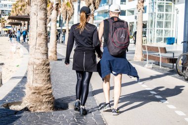 Tel Aviv, İsrail - 13 Şubat 2022 Tel Aviv Güvertesi 'nde yürüyen kimliği belirsiz insanlar, İbranice' de Tayelet olarak bilinir, İsrail 'in Tel Aviv kentindeki Akdeniz kıyısı boyunca uzanır.