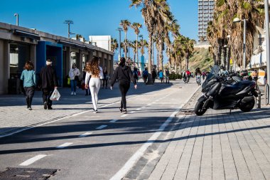 Tel Aviv, İsrail - 13 Şubat 2022 Tel Aviv Güvertesi 'nde yürüyen kimliği belirsiz insanlar, İbranice' de Tayelet olarak bilinir, İsrail 'in Tel Aviv kentindeki Akdeniz kıyısı boyunca uzanır.