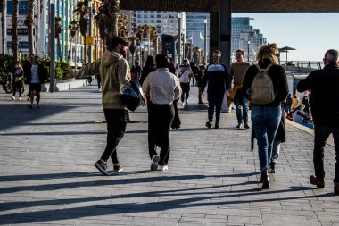 Tel Aviv, İsrail - 13 Şubat 2022 Tel Aviv Güvertesi 'nde yürüyen kimliği belirsiz insanlar, İbranice' de Tayelet olarak bilinir, İsrail 'in Tel Aviv kentindeki Akdeniz kıyısı boyunca uzanır.